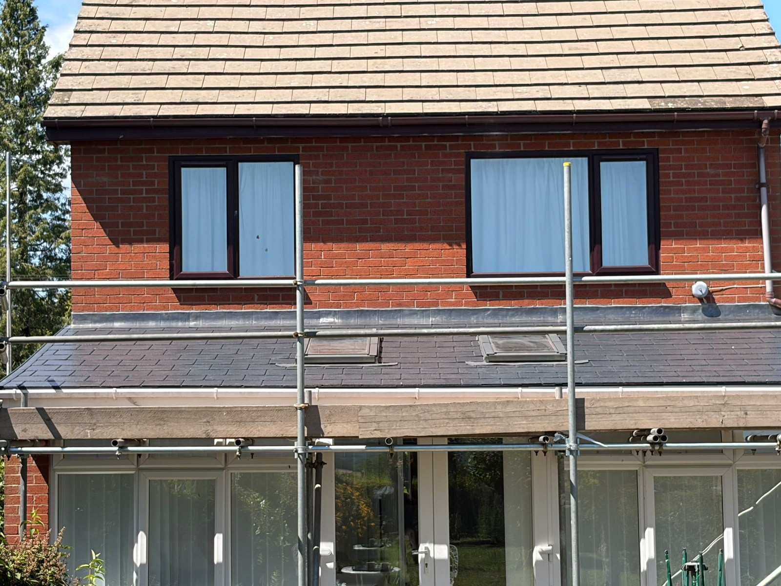 Conservatory warm roof conversion in progress with new synthetic slate being installed