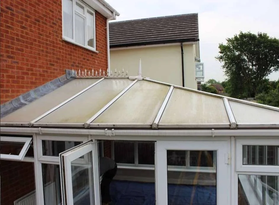 Old conservatory with a tired polycarbonate roof before the warm roof conversion